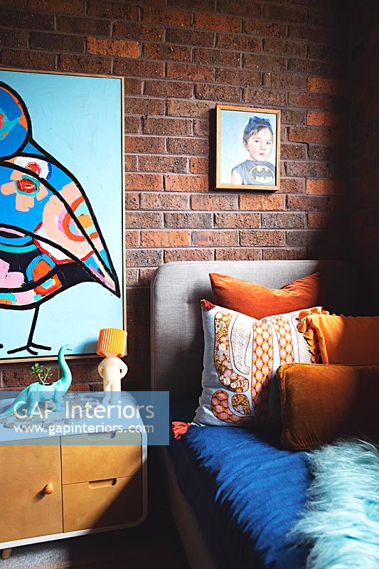 Large colourful painting on exposed brickwork wall in childrens bedroom 