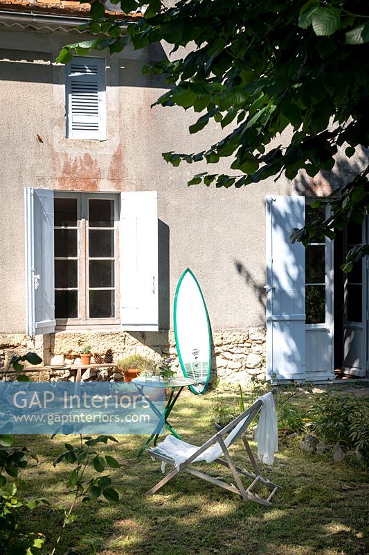 Country garden with surfboard leaning up against house
