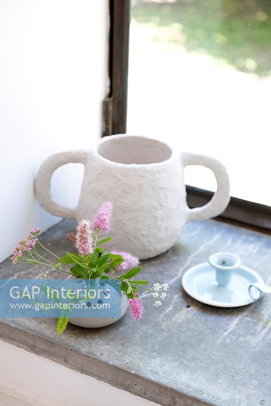flowers in tiny pot on windowsill with fabric cup