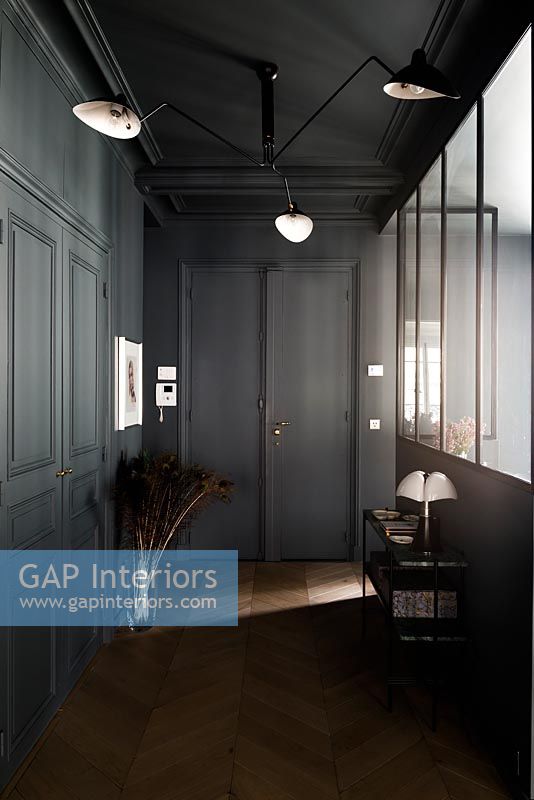 Hallway with black painted ceiling and walls and parquet floor 