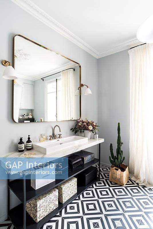 Large mirror over marble sink unit in monochrome bathroom 
