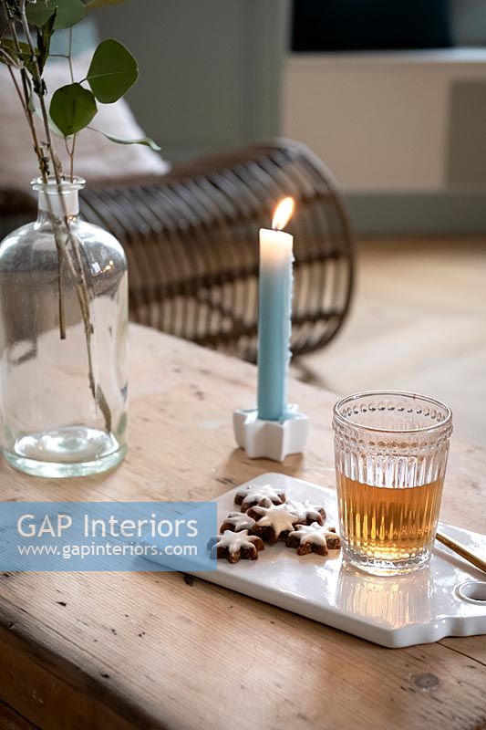 Detail of Christmas biscuits, drink and candle on wooden table 