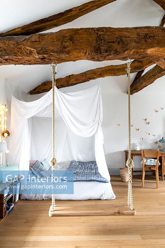 Swing in childrens bedroom with canopy over bed 