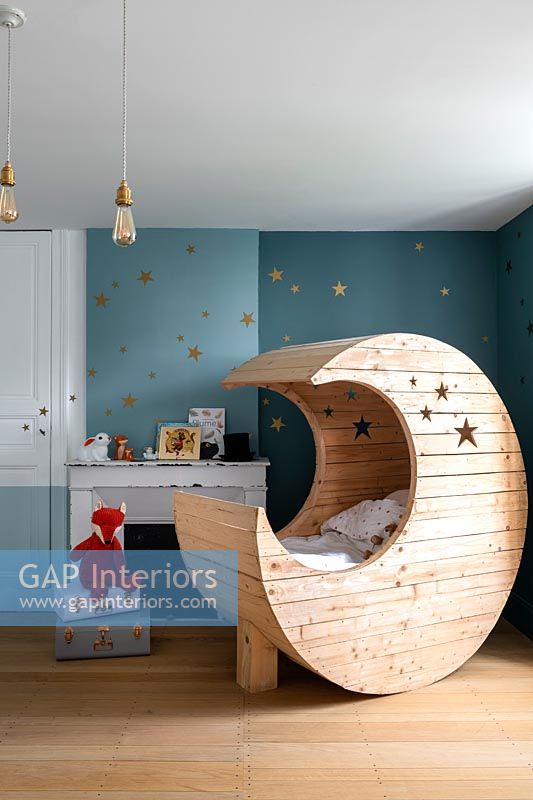 Wooden moon shaped cot bed in modern childrens bedroom 