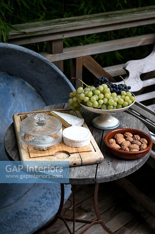 Small garden table with cheese, fruit and nuts 