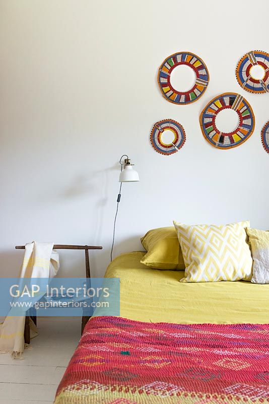 Display of colourful rings on modern country bedroom wall 