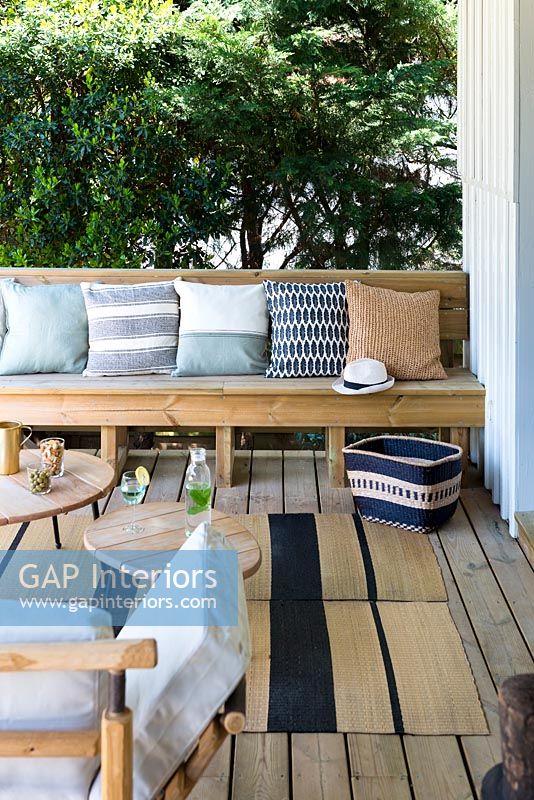 Wooden bench seating with cushions in outdoor living area 