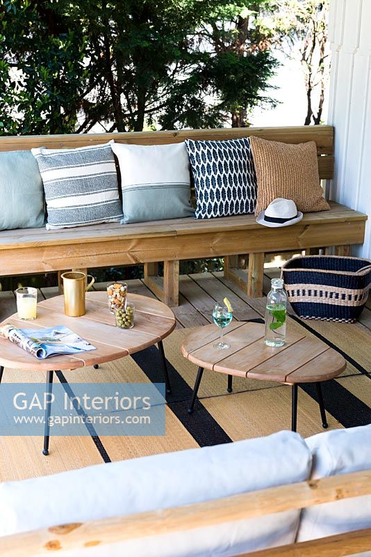 Wooden furniture and cushions in outdoor living room area 