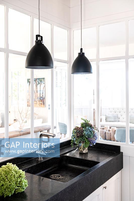 Black and white sink with pendant lights and view through internal windows 