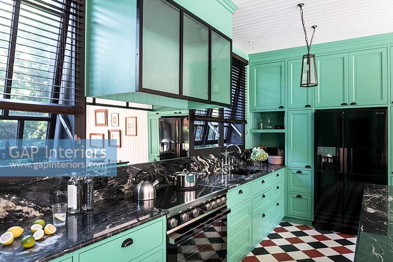 Bright green kitchen with black, white and red checkerboard floor 