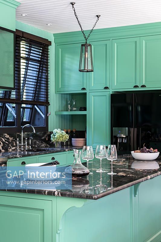 Mint green modern kitchen with black marble worktop 