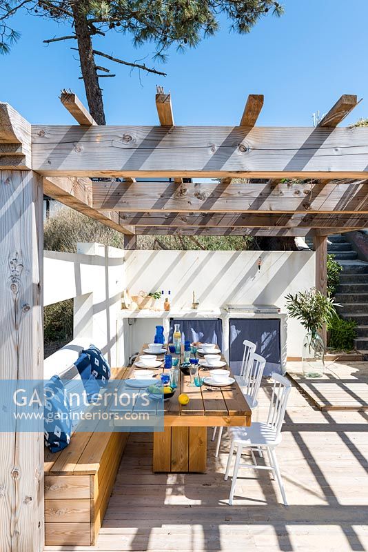 Wooden pergola over outdoor dining and kitchen area on terrace 