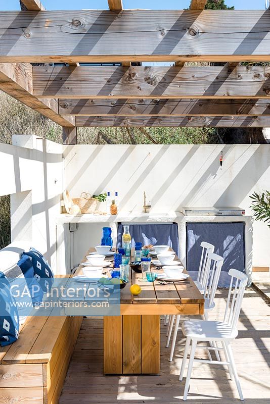 Outdoor dining and kitchen area on terrace with pergola 