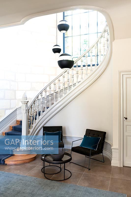 Classic staircase with modern furniture and pendant lights 