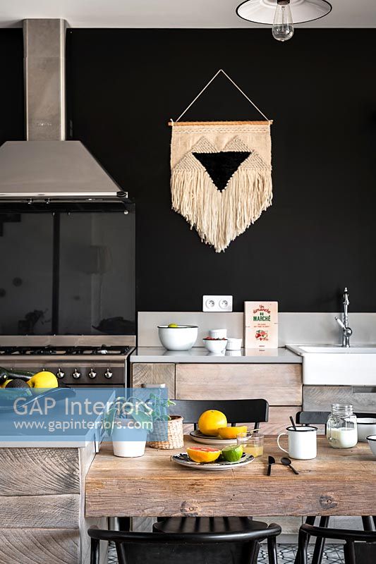 Macrame wall hanging in modern black and white kitchen 