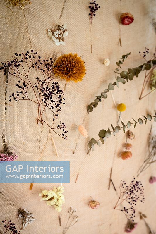 Dried flowers displayed on hessian wall hanging 