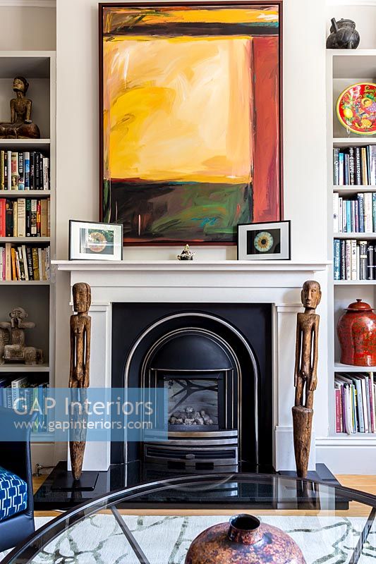 Colourful artwork over fireplace 