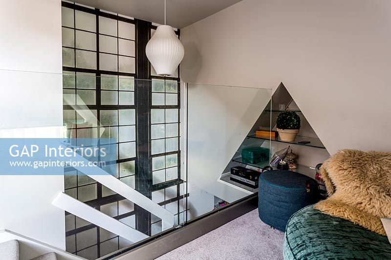 Mezzanine room with glass wall and triangular alcove shelves 
