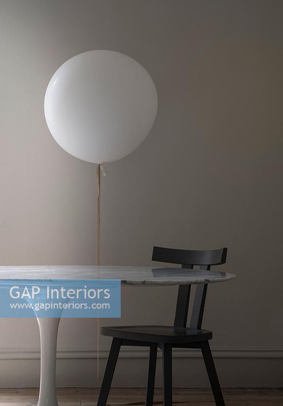 White balloon lamp next to table and chair 
