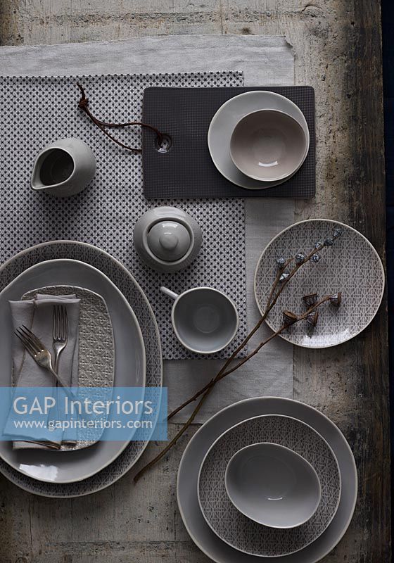 Overview of place settings on dining table in grey muted tones 