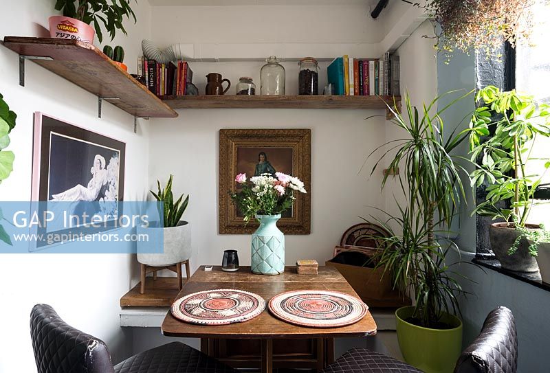 Tiny dining area with folding table and houseplants 
