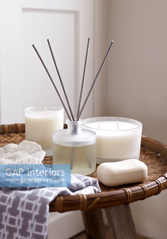 Candles, scent sticks and soap on wicker table 