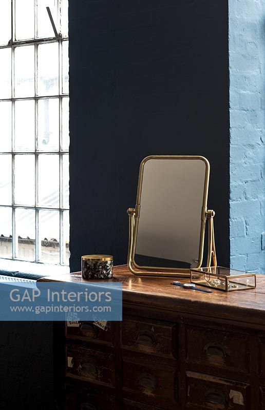 Gold framed mirror on dressing table