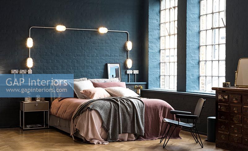 Blue painted brickwork walls in modern bedroom 
