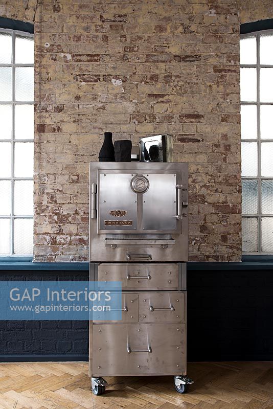 Industrial steel cabinet next to exposed brick wall 