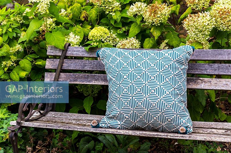 Patterned cushion on wooden bench 