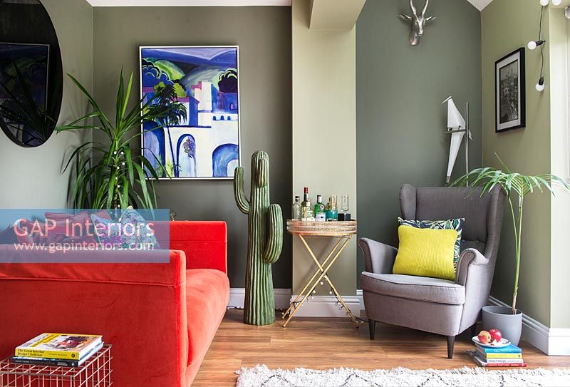 Green painted walls and red sofa in modern living room 