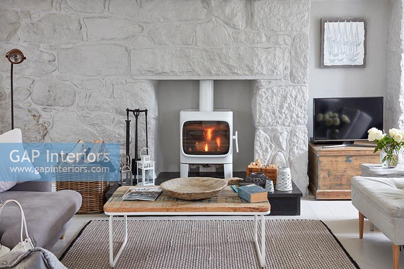 Lit wood burning stove in modern country living room 