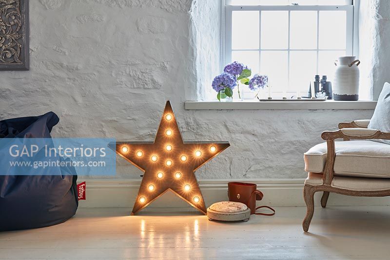 Modern star shaped light on floor of country living room 