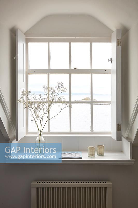 Sea view through windows with white shutters 