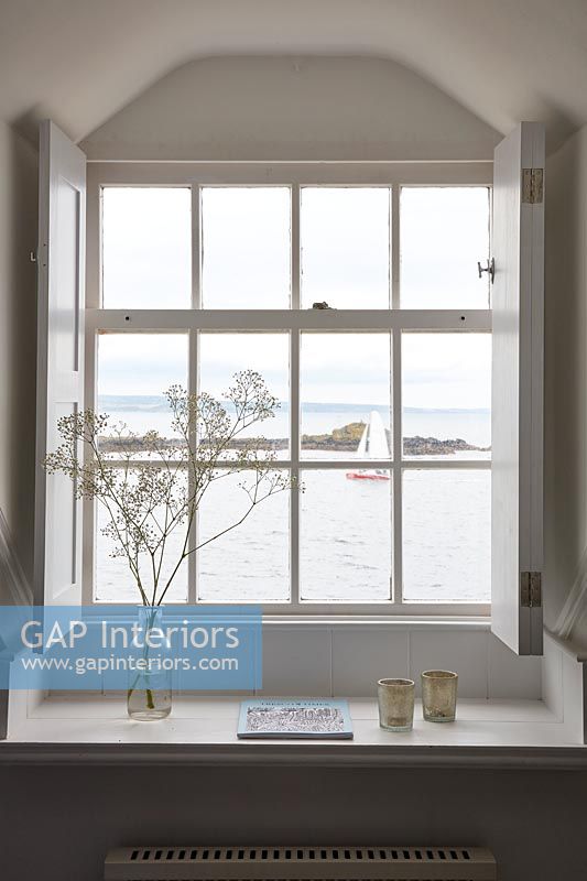 View of sea and boats through coastal cottage window 