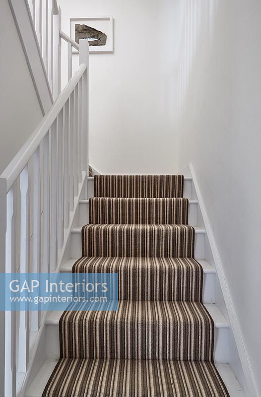 Brown stripy stair carpet on white staircase 