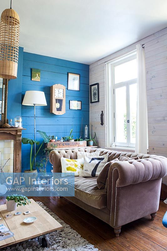 Modern living room with blue painted wooden wall 