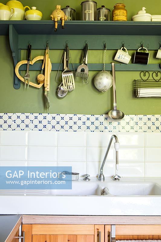 Utensils on hooks above country kitchen sink