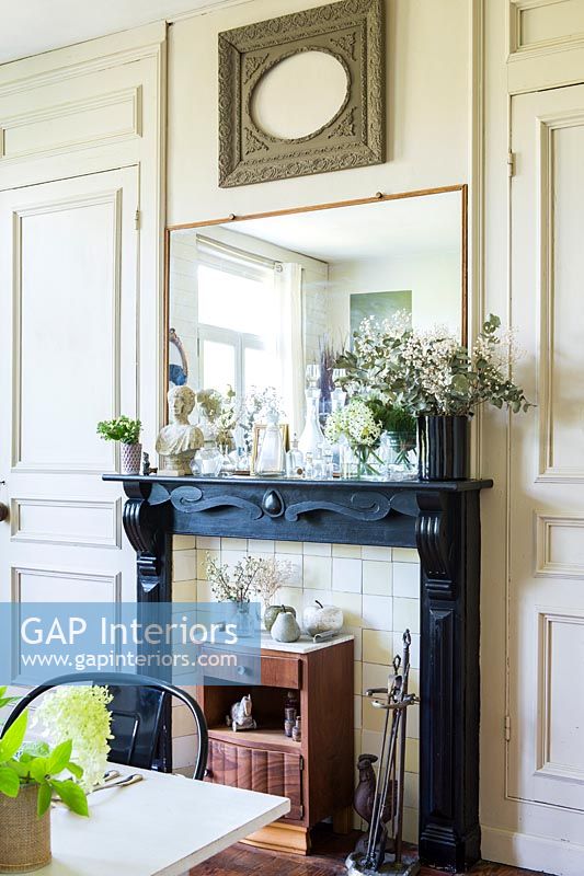 Fireplace with small vintage cabinet and black mantelpiece 
