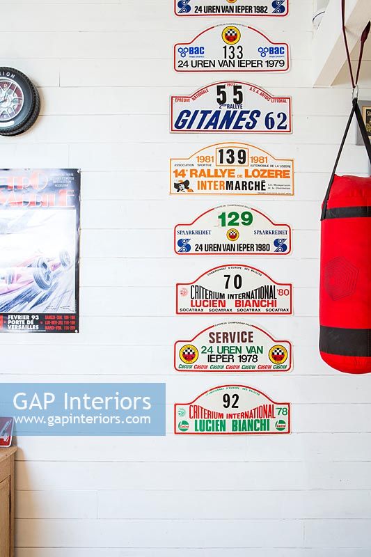 Racing car signs displayed on wall next to punch bag 