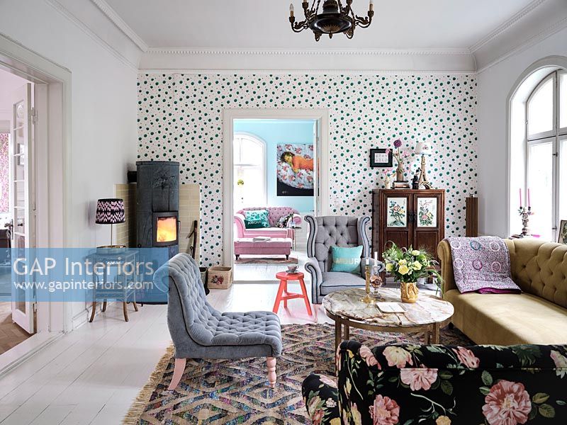 Spotty feature wall in eclectic living room with log burning stove 