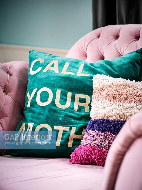 Colourful cushions on pink sofa 