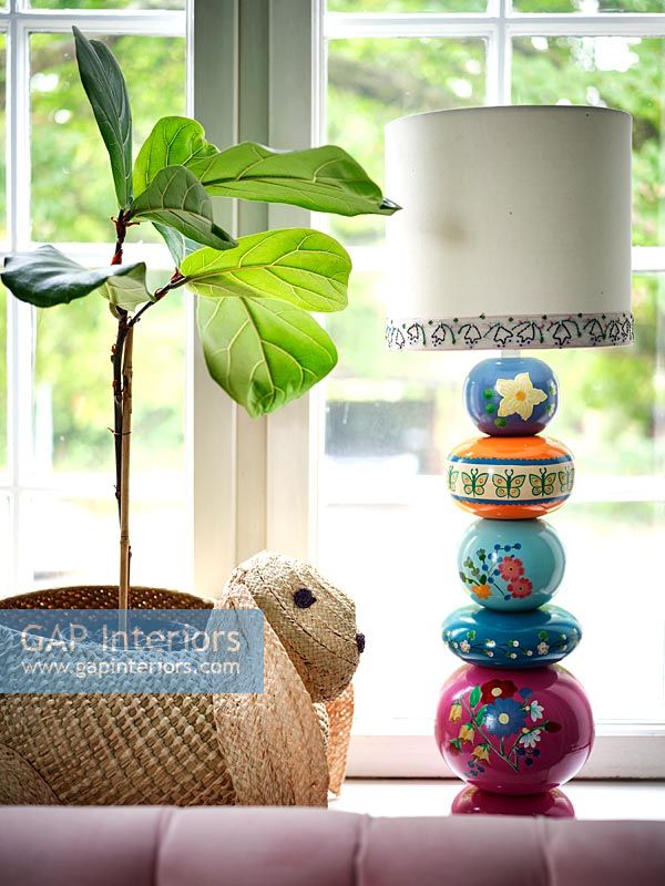 Colourful lamp stand on windowsill with rabbit shaped basket 