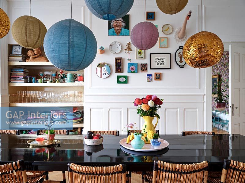 Modern dining room with variety of paper lantern spheres over table 