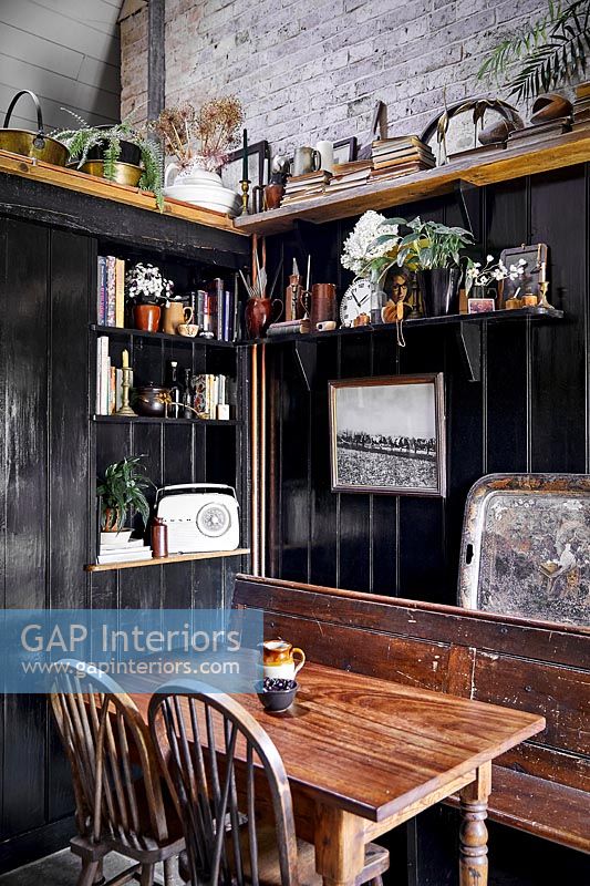 Small dining area with black painted wooden panelling 
