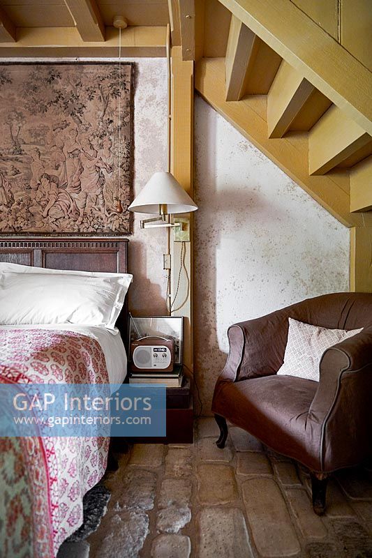 Country bedroom with exposed staircase 