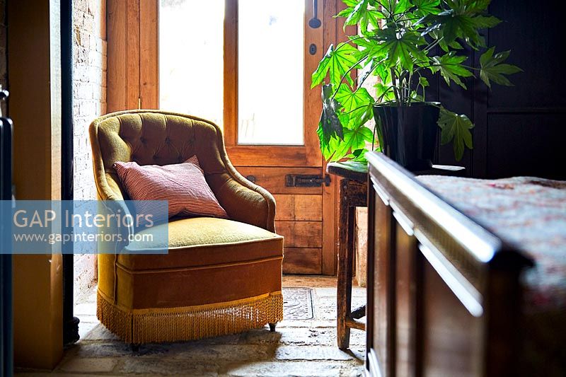 Classic armchair next to window of country bedroom 