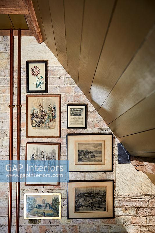 Framed paintings on exposed brick wall 