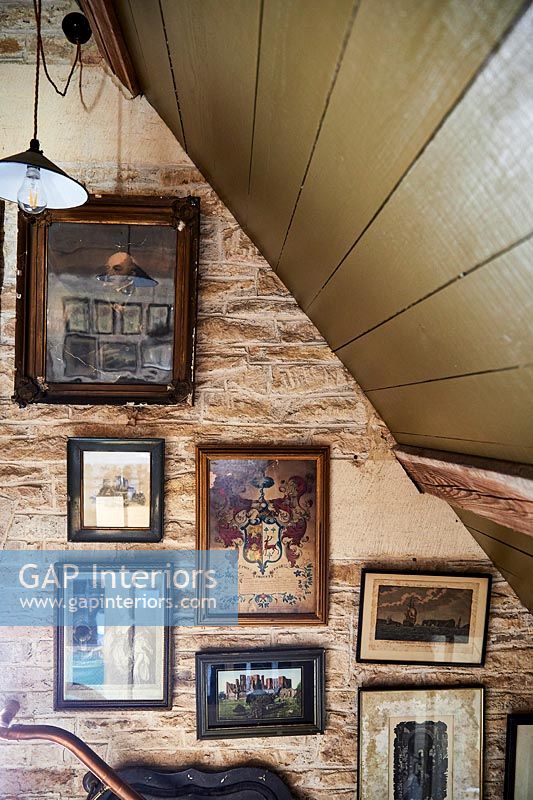 Framed paintings on exposed brick wall 