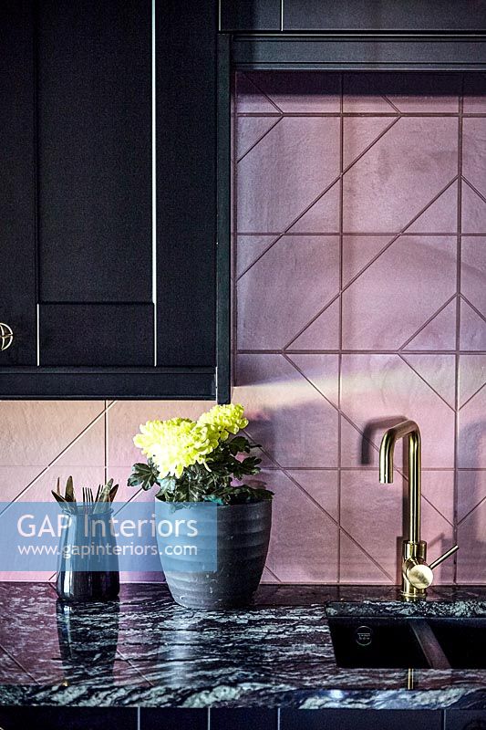 Pink tiled splashback in black kitchen 